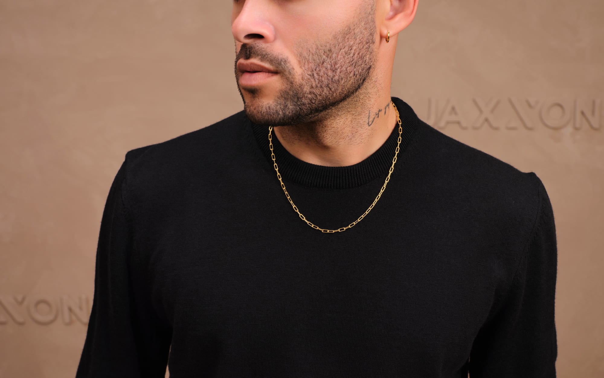 Don Benjamin wearing JAXXON's Gold 3mm Paperclip Chain styled with a black sweater.