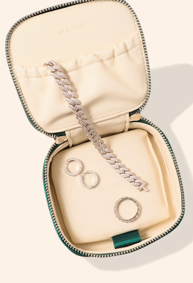 An overhead view of JAXXON's Emerald Travel Jewelry Case lying open with several pieces of JAXXON jewelry inside.