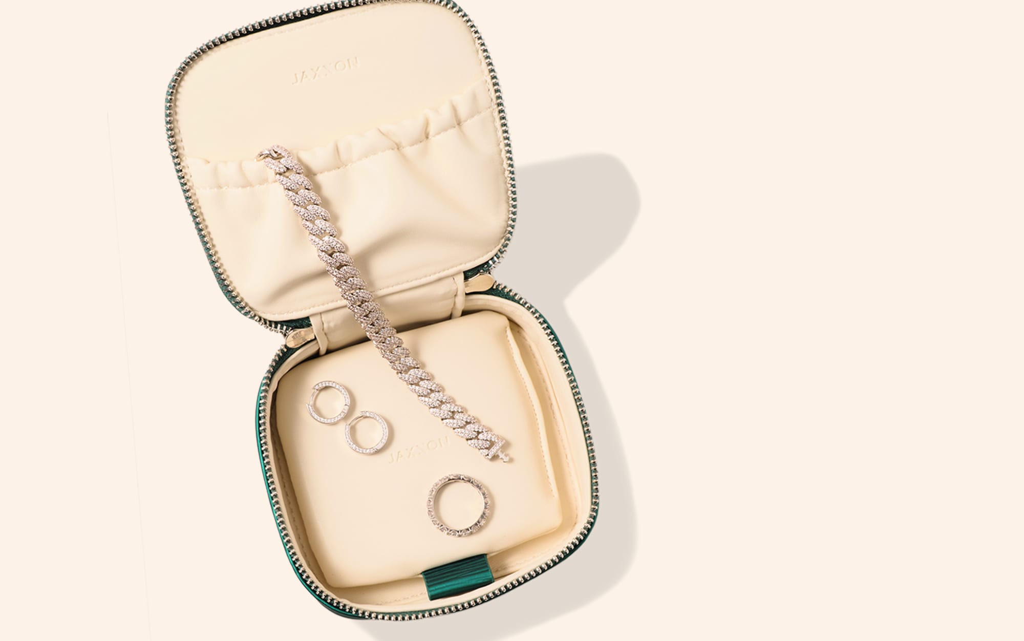An overhead view of JAXXON's Emerald Travel Jewelry Case lying open with several pieces of JAXXON jewelry inside.