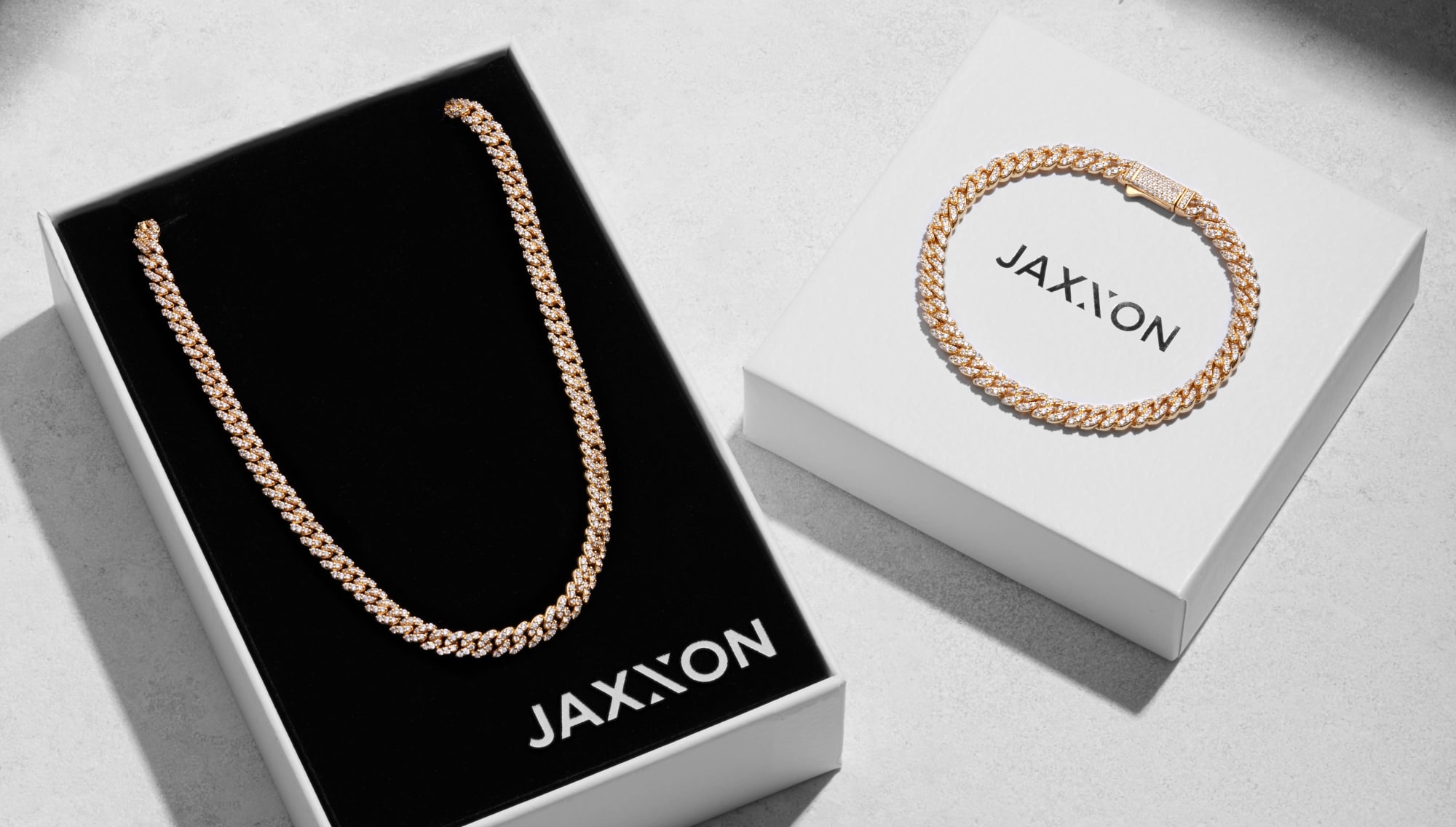 An overhead view of the JAXXON Gold Iced Out Cuban Essentials Set inside JAXXON packaging.