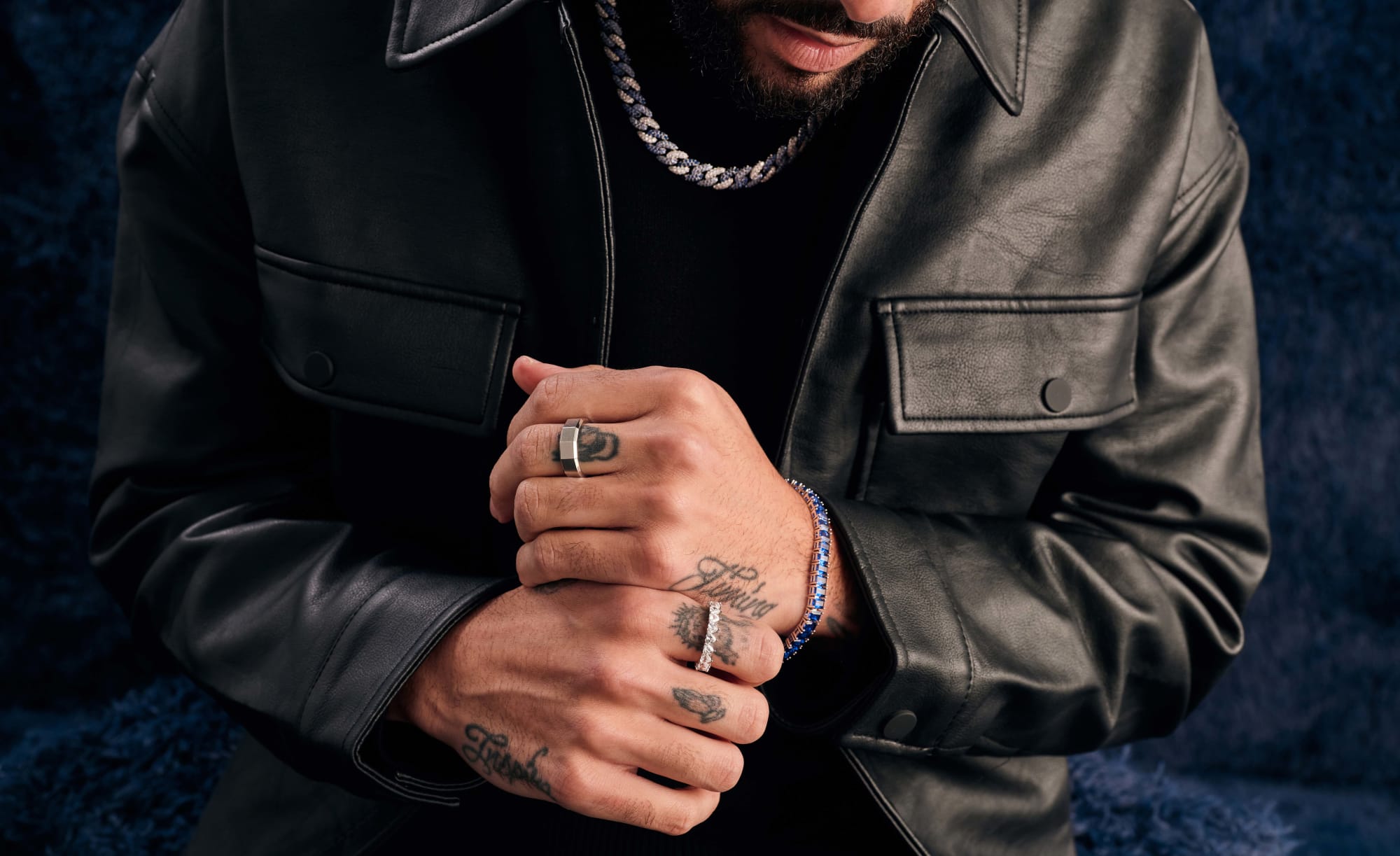 Don Benjamin wearing a black leather jacket and pants, and JAXXON jewelry pieces featuring the Blue Iced Out Cuban Link Chain.